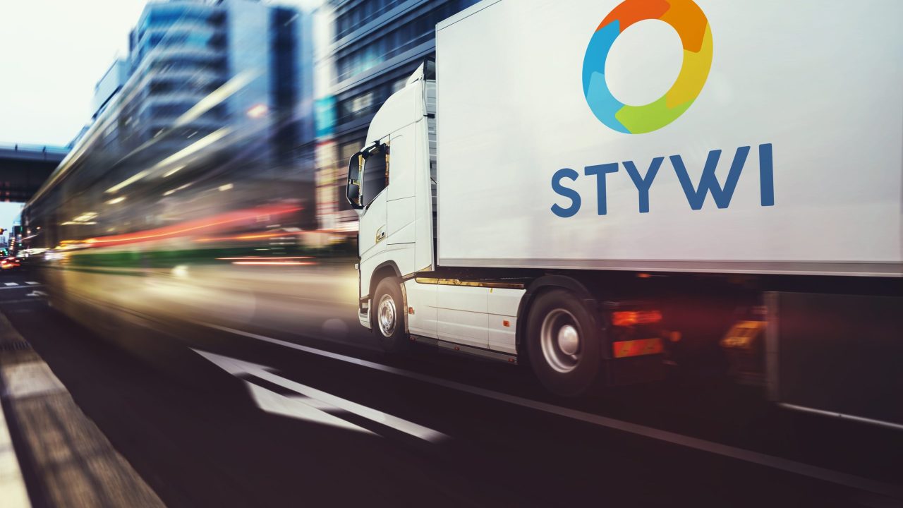 White truck moving fast on the road in a modern city with light effect